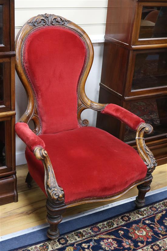 A Victorian carved walnut open armchair on turned legs